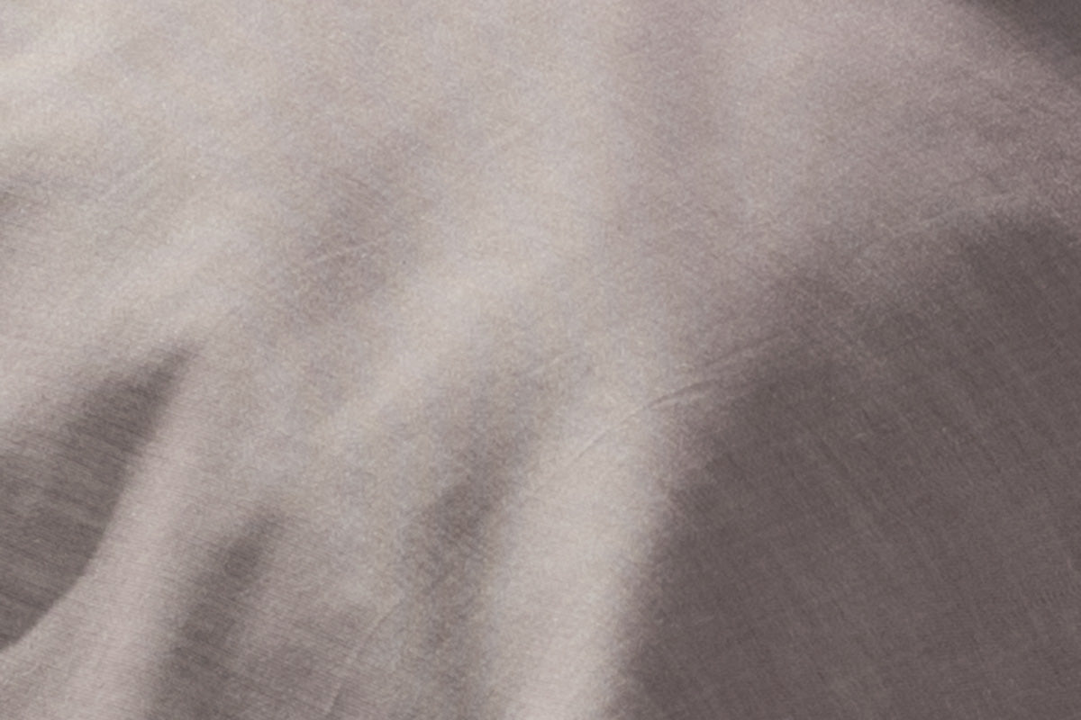 Hochwertiges Spannlaken Caviar in elegantem Damast-Gewebe, geschmeidig und glänzend in grauer Farbe. Nahaufnahme zeigt die charakteristische Damast-Struktur mit mattem und glänzendem Effekt. Luxuriöse Stoffqualität für gehobenen Schlafkomfort.