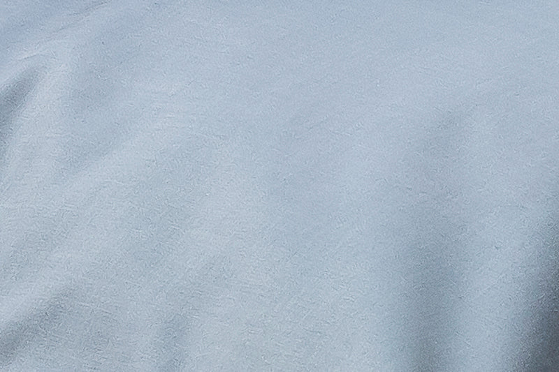 Hochwertige Bettwäsche Mare Damast in elegantem Blaugrün, fein meliert gewebt im exklusiven Satinbindung-Design. Detailaufnahme zeigt die edle Stoffstruktur und den charakteristischen Glanz der hochwertigen Baumwolldamast-Qualität.