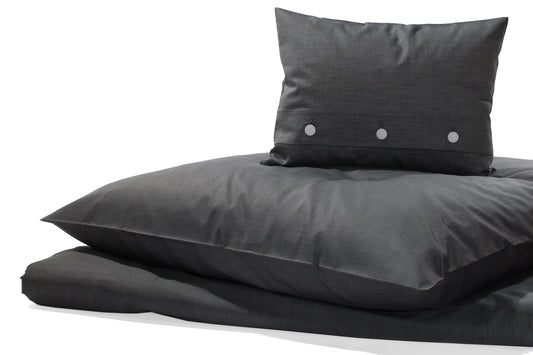 Fast schwarze Damast Bettwäsche Nero: Elegante anthrazitfarbene Bettwäsche aus hochwertigem Damast-Gewebe mit weißem Kettfaden, meliert gewebt. Kissenbezug mit dekorativen Knöpfen und Bettdeckenbezug in luxuriöser Satinbindung, ideal für modernes Schlafambiente.