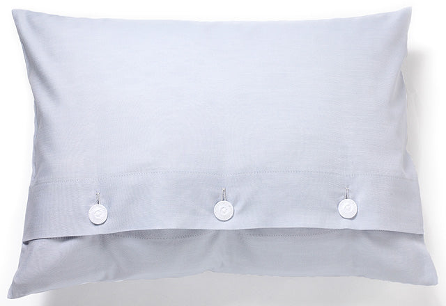 Bettwäsche Perla Damast Kissenbezug in hellem Blau, hochwertige Satinbindung mit dekorativen weißen Knöpfen, elegant meliertes Design mit weißem Kettfaden, luxuriöse Damast-Qualität made in Italy.