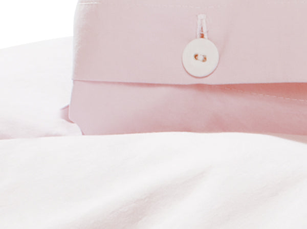Bettwäsche Puder Gewaschene Baumwolle: Hochwertiger Bettbezug in zartem Puder-Rosa mit weißem Wäscheknopf, Detail der charakteristischen Stoffkontor-Knopfleiste, elegante Knitteroptik aus italienischer Webung.