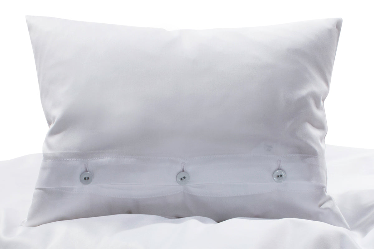 Hochwertige Bettwäsche Mako-Satin weiss mit eleganter Knopfleiste, glänzender Oberfläche und klassischem Design. Kissen zeigt drei stoffbezogene Wäscheknöpfe in perfekter Verarbeitung. Exklusiv in Italien gefertigt von Stoffkontor.