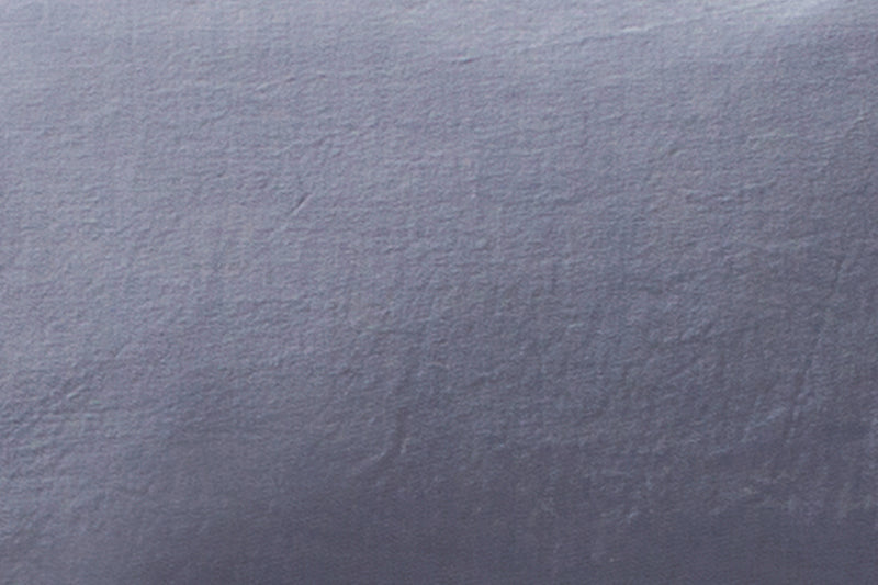Bettwäsche Stonewashed Denim Ciclamino: Hochwertige Bettwäsche in zartem Lavendelblau mit grauem Unterton, stonewashed verarbeitet für einen weichen, pudrigen Look. Detailaufnahme der hochwertigen Baumwollstruktur mit charakteristischer Denim-Optik. Qualität made in Italy.