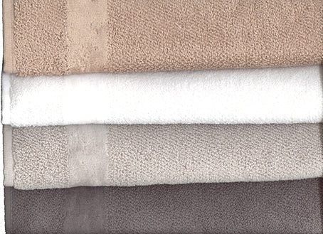 Handtuch Fyber Carrara Grigio: Elegante gestapelte Handtücher in harmonischen Farbtönen von Beige über Weiß bis Grau, hochwertige Frotteequalität mit sichtbarer Strukturoberfläche.