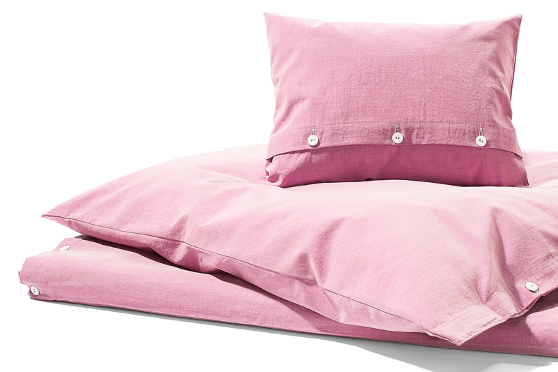 Bettwäsche Stonewashed Denim Pink: Hochwertige Bettwäsche im Jeans-Look aus Italien, in zartem Rosa mit stonewashed Effekt. Kissenbezüge mit eleganten stoffbezogenen Knöpfen, casual und modern. Pflegeleichte Baumwollqualität für zeitlosen Komfort.