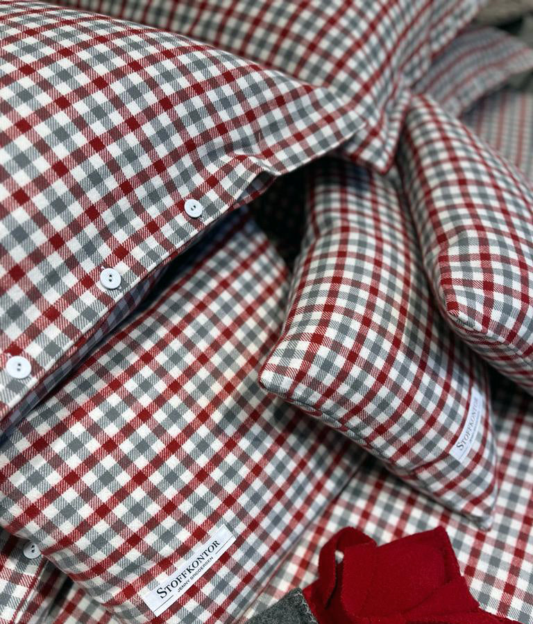 Bettwäsche Klassisches Karo Flanell Rot: Hochwertige Bettwäsche aus reiner Baumwolle im traditionellen Karomuster in Rot und Grau, mit eleganten stoffbezogenen Wäscheknöpfen und klassischer Knopfleiste. Die weiche Flanellqualität zeigt sich in präzise gewebten Karos und sorgfältig verarbeiteten Details.