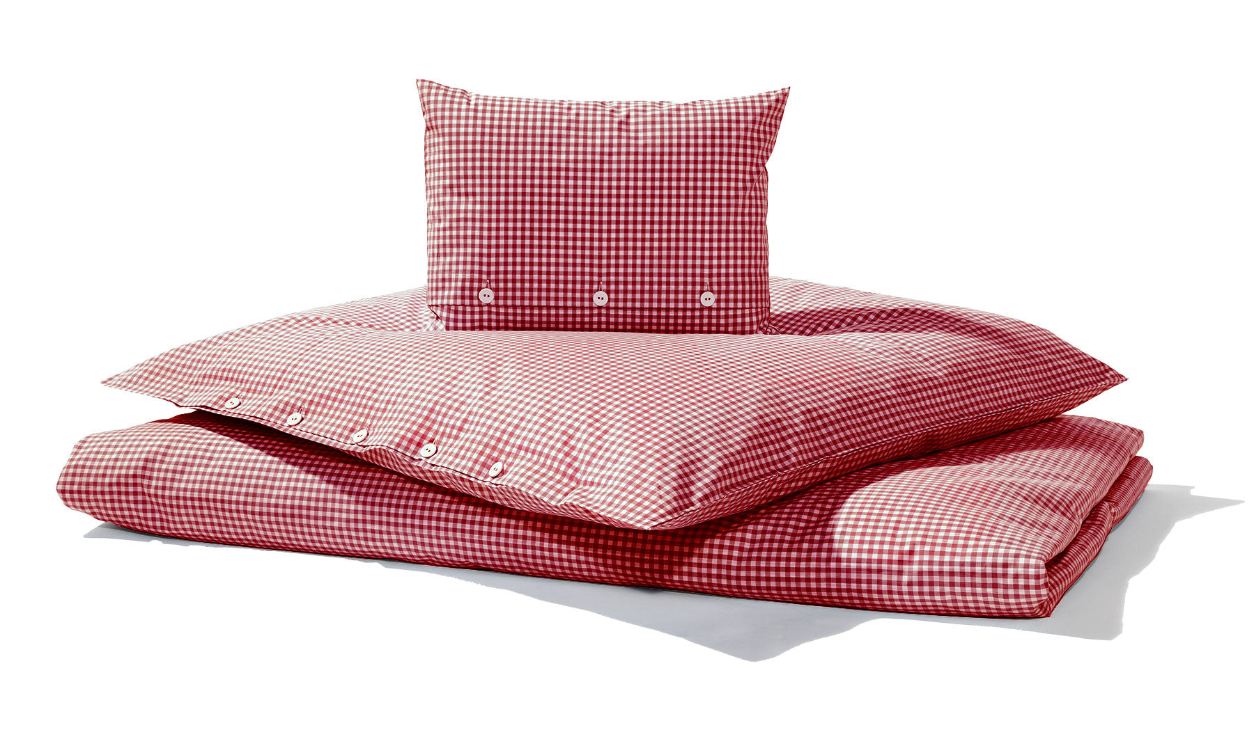 Bettwäsche Red Nose Red Vichy Karo: Hochwertige Bettwäsche-Set aus reiner Baumwolle im klassischen rot-weißen Vichy-Karomuster, bestehend aus Bettbezug und Kopfkissenbezug mit eleganter Knopfleiste, fotografiert auf weißem Hintergrund mit natürlichem Schattenwurf