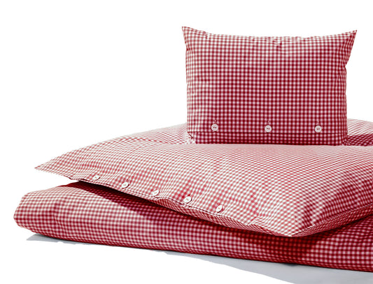 Bettwäsche Red Nose Red Vichy Karo: Hochwertige Bettwäsche im klassischen rot-weißen Karomuster mit eleganten Stoffknöpfen. Der Bettbezug und Kissenbezug aus reiner Baumwolle zeigen ein traditionelles Vichy-Karomuster in leuchtendem Rot und Weiß, perfekt für ein gemütliches Schlafambiente.