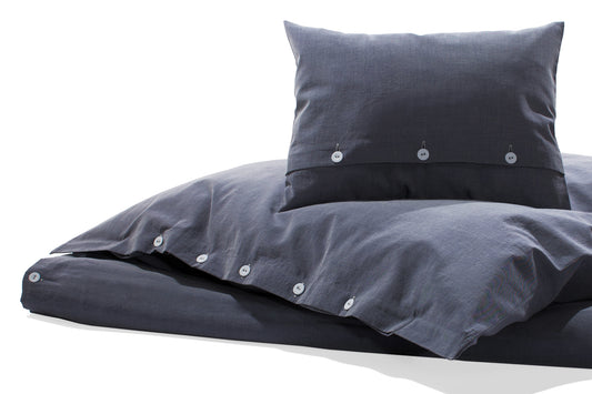 Bettwäsche Bluette Damast: Hochwertige Bettwäsche in kraftvollem Blau mit eleganter Damastbindung, verdeckter Knopfleiste und weißen Kettfäden. Kissen und Bettdeckenbezug in moderner Ausführung auf weißem Hintergrund fotografiert.