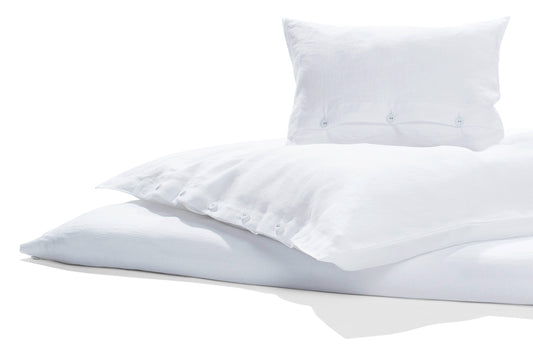 Bettwäsche Reines Leinen weiss, vorgewaschen GOTS: Hochwertige weisse Leinenbettwäsche in elegantem Design, mit klassischer Knopfleiste. Butterweich vorgewaschen, nachhaltig GOTS-zertifiziert. Kissenbezug und Bettbezug in harmonischer Komposition auf hellem Hintergrund fotografiert.