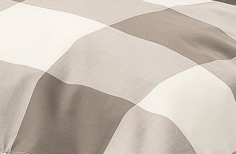 Bettwäsche Grosses Karo Treibholz: Hochwertige Bettwäsche mit großem Karomuster in elegantem Treibholz-Grau und Weiss, aus reiner Baumwolle gefertigt. Die weichen Falten der Textilie zeigen die hochwertige Stoffqualität und das klassische Design.