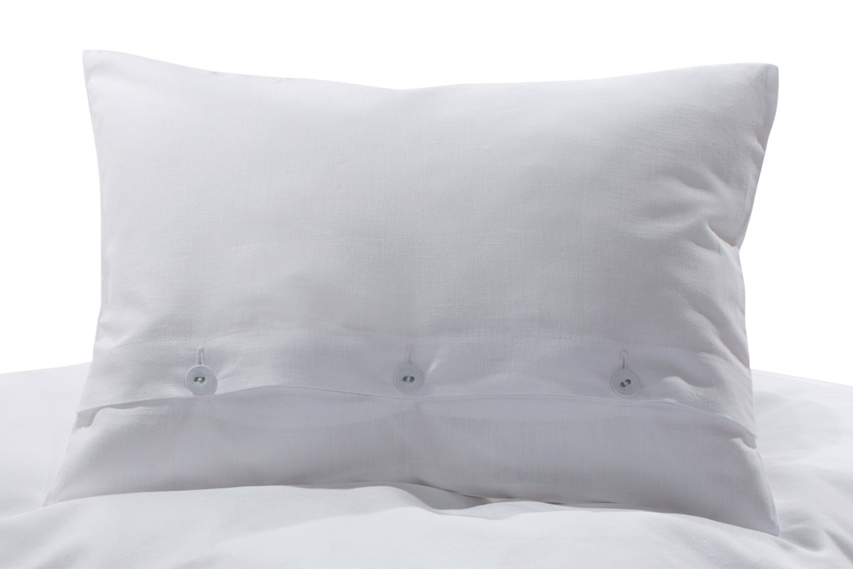 Bettwäsche Halbleinen Weiß: Elegantes Kopfkissen in reinem Weiß aus hochwertigem Halbleinen mit charakteristischer Struktur und klassischer Knopfleiste. Die harmonische Kombination aus Baumwolle und Leinen verleiht dem Kissen eine edle, zeitlose Optik. Handgefertigt in Italien mit gezwirnten Wäscheknöpfen.