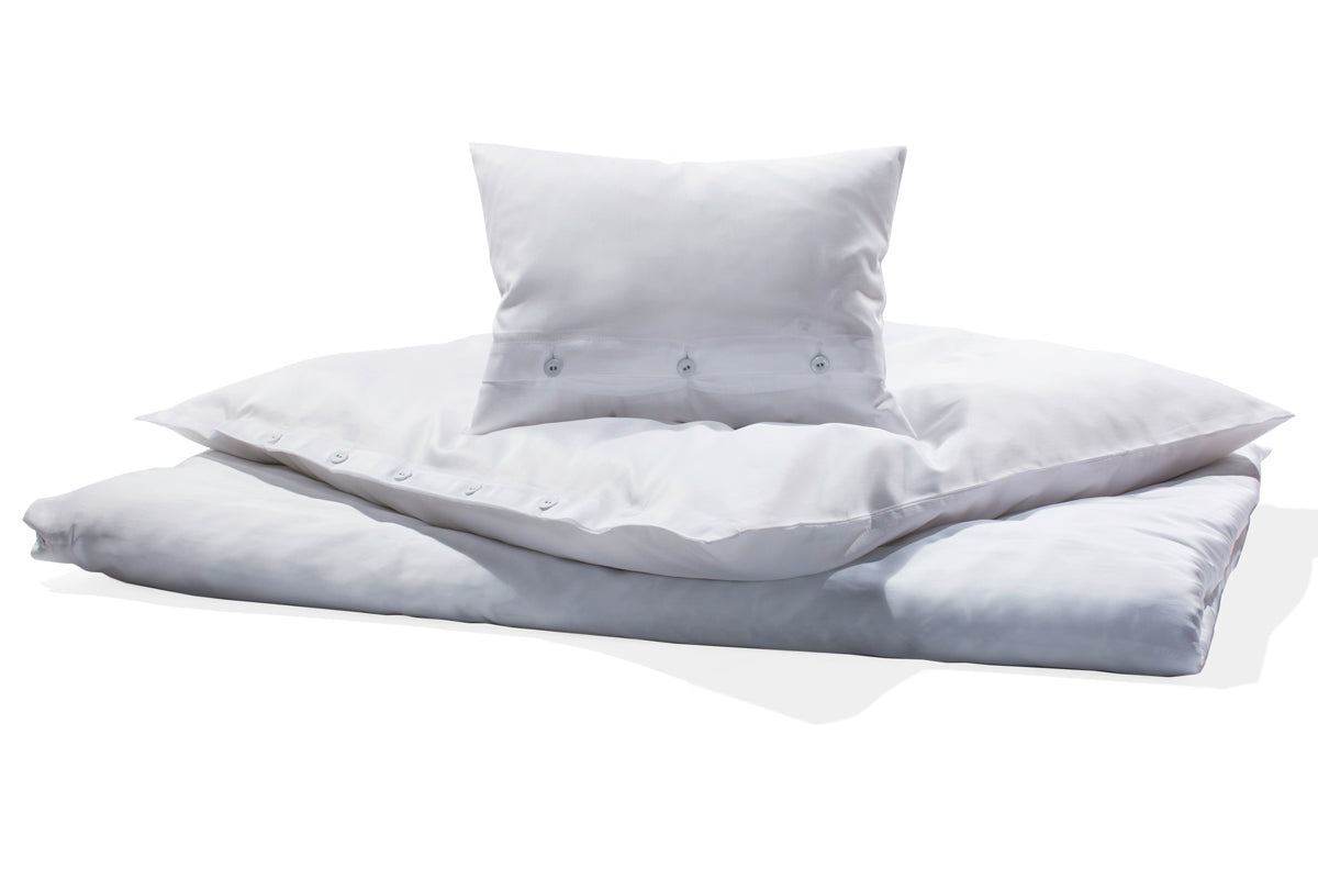 Hochwertige Mako-Satin Bettwäsche in strahlendem Weiss mit klassischer Knopfleiste, elegant glänzender Oberfläche und hochwertiger italienischer Verarbeitung. Bettbezug und Kissen aus feinem Satingewebe für zeitlosen Schlafkomfort.