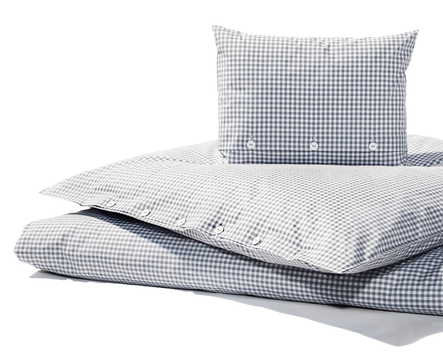 Bettwäsche Nordisch by Nature Vichy Karo Silbergrau: Hochwertige Bettwäsche aus reiner Baumwolle im klassischen Vichy-Karomuster in Silbergrau und Weiss. Der Bezug zeigt traditionelle Stoffknöpfe und eine elegante Knopfleiste. Fotografiert in natürlichem Licht auf weissem Hintergrund.