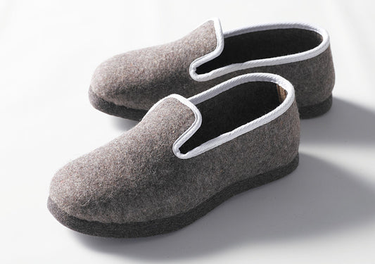 Handgefertigte geschlossene Hausschuhe aus grauem Wollfilz mit weißer Einfassung, dicke Filzsohle für maximalen Komfort. Klassisches Design der Stoffkontor Pantoffeln mit eleganter weißer Bordüre. Hausschuhe geschlossen, Band weiß - Pantoffeln, Hersteller: Stoffkontor