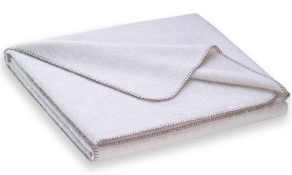 Steiner1888 Wolldecke Nora Perle: Elegante Naturdecke aus 50% Merinowolle und 50% Alpaka in perlfarbenem Ton mit kontrastierender Kanteneinfassung. Die gefaltete Decke zeigt die hochwertige Verarbeitung und weiche Textur. Wolldecken, Hersteller: Steiner 1888
